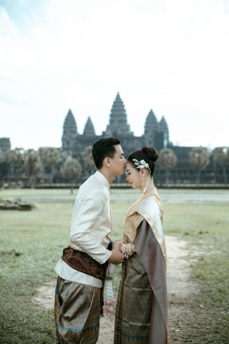 A couple in traditional Khmer clothing shares an intimate moment at Angkor Wat, Cambodia.